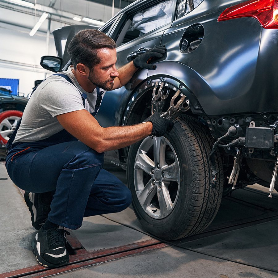 Technician refitting a wheel and arch liner after body repair