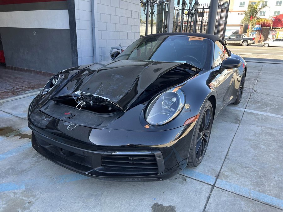 Black Porsche 911 Cabriolet with front-end collision damage